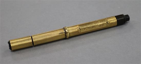 An Edwardian engine turned yellow metal fountain pen, with engraved inscription, 12.6cm.